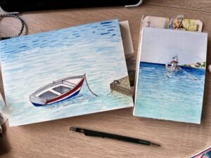 two sketchbooks, each with a tiny painting of a boat on the sea